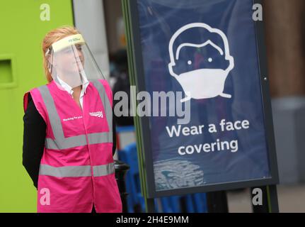 Ein Mitarbeiter von Network Rail mit Schutzvisier steht neben einem Schild, das Pendler aufzeigt, bei der Nutzung öffentlicher Verkehrsmittel am Bahnhof Charing Cross eine Gesichtsbedeckung zu tragen. Während London sich darauf vorbereitet, der Öffentlichkeit wieder zugänglich zu machen, wenn die Aufhebung weiterer Sperrbeschränkungen in England am Samstag in Kraft tritt. Bilddatum: Freitag, 3. Juli 2020. Stockfoto