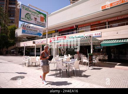 Ein Mann mit Gesichtsbedeckung geht an einer leeren Bar im englischen Viertel Levante in Benidorm vorbei, das normalerweise von britischen Touristen überschwemmen wird, und bleibt fast leer, nachdem die britische Regierung allen Touristen, die wegen der hohen COVID-19-Fälle aus Spanien reisen, die Quarantäne auferlegt hat. Bilddatum: Mittwoch, 29. Juli 2020. Stockfoto