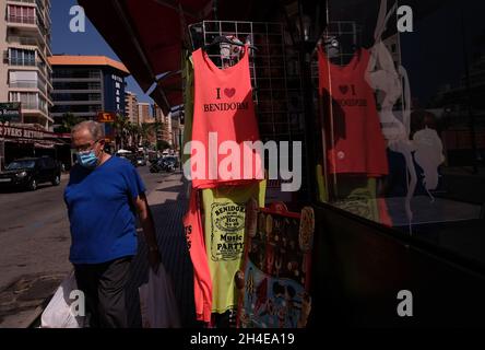 Ein Mann mit Gesichtsbedeckung geht an einem Souvenirladen im englischen Stadtteil Levante in Benidorm vorbei, der normalerweise von britischen Touristen überschwemmen wird, aber fast leer bleibt, nachdem die britische Regierung allen Touristen, die aufgrund der hohen COVID-19-Fälle aus Spanien reisen, Quarantäne auferlegt hat. Bilddatum: Mittwoch, 29. Juli 2020. Stockfoto