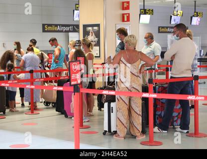 Eine Gruppe von Reisenden, die am Jet2-Check-in-Schalter am internationalen Flughafen von Ibiza in die britische Warteschlange zurückkehrt, hat das Reiseunternehmen angekündigt, dass es Kunden im Urlaub in Spanien, die gebeten wurden, frühzeitig zurück nach Großbritannien zu fliegen, erstatten wird. Bilddatum: Sonntag, 2. August 2020. Stockfoto