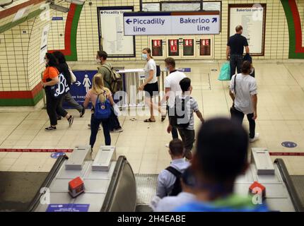 Pendler, die eine schützende Gesichtsmaske tragen, während sie durch die Piccadilly Station in London reisen, da Gesichtsbedeckungen in den öffentlichen Verkehrsmitteln in England obligatorisch werden. Bilddatum: Freitag, 7. August 2020. Stockfoto
