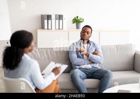 Psychologe hilft schwarzen männlichen Patienten, arbeitet mit unglücklichen afroamerikanischen Mann, Unterstützung in der Klinik Stockfoto