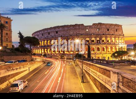 Schöne Aussicht auf das Kolosseum und eine Straße in der Nähe bei Sonnenuntergang, Rom, Italien Stockfoto