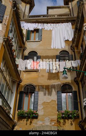 An der Wäscheleine in Venedig hängen Kleider aus dem Gebäude Stockfoto