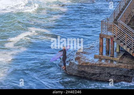 Ein Surfer mit einem Surfbrett im Sunset Cliffs Natural Park. San Diego, Kalifornien, USA. Stockfoto