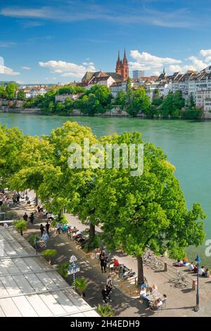Blick von der Flusspromenade auf das Basler Münster und die Basler Altstadt mit dem türkis farbigem Rhein Fluss und der bebten Uferpromenade im Vord Stockfoto