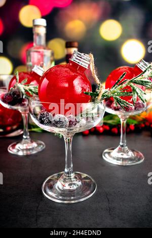 Holiday Gin und Tonic Cocktail in einem Weihnachtsschmuck: Ein Cranberry- und Gin-Cocktail in einem Coupé-Glas Stockfoto