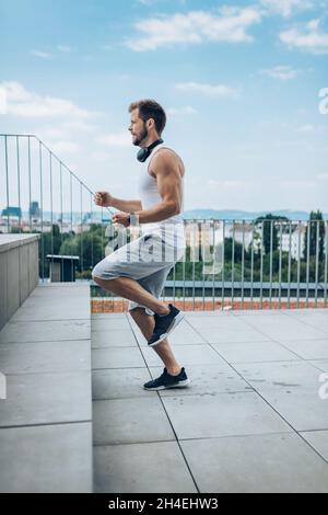 Schöner junger Mann, der draußen trainiert und trainiert Stockfoto