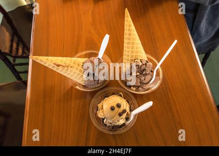 Leckere Schokoladen-Eiszapfen und Tassen mit Löffeln Stockfoto