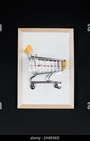 Angebot „Black Friday“. Mini-Warenkorb im Rahmen auf schwarzem Hintergrund. Banner für Werbung. Stockfoto