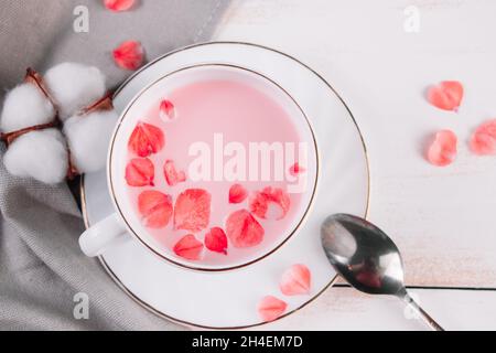 Rosa Matcha mit Rosenblättern. Entspannender Drink für die lange Zeit. Trendiger veganer Tee auf weißem Hintergrund. Stockfoto