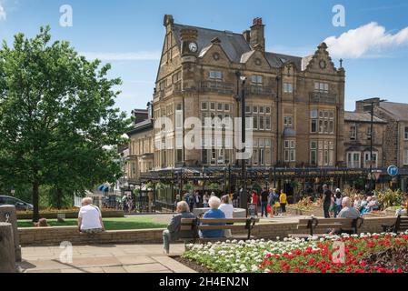 Harrogate Yorkshire, Blick im Sommer auf Menschen, die sich in den Cenotaph Gardens entspannen und auf Bettys Tea Rooms und im Zentrum von Harrogate, Großbritannien, blicken Stockfoto