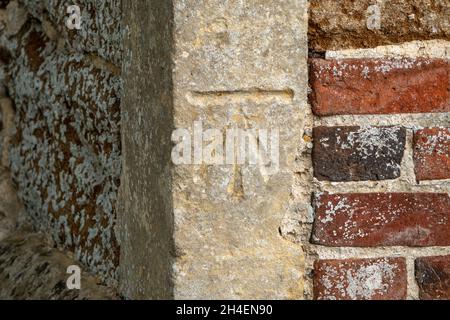 Ein Vermesser benaktert den Eckstein der Kirche St. Johannes der Täufer Wantisden, Suffolk, Großbritannien Stockfoto