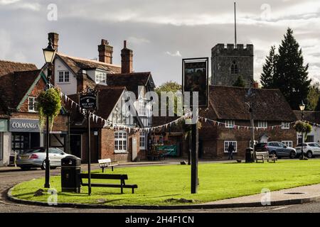 Das Ortsnamenschild auf dem Grün mit alten Gebäuden und Kirchturm. High Street, Chalfont St Giles, Buckinghamshire, England, Großbritannien, Großbritannien Stockfoto