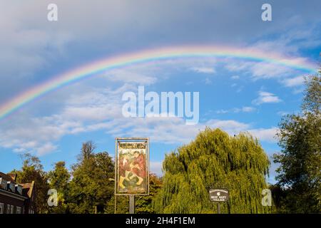Voller Regenbogen am Himmel über dem Dorfschild. High Street, Chalfont St Giles, Buckinghamshire, England, Großbritannien, Großbritannien Stockfoto