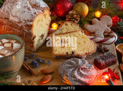 Stimmungsvolle Weihnachts- und Neujahrskomposition auf braunem Hintergrund, Kaffee, Kakao, Marschmalchen, Weihnachtskuchen, Girlanden, Kerzen, Tannenzweige, Co Stockfoto