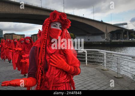 Glasgow, Schottland, Großbritannien, November 02 2021. Extinction Rebellion rot umarmte Demonstranten reisen in einer Prozession durch die Stadt zu den COP 26 Barrikaden, hinter denen sich die Staats- und Regierungschefs der Welt versammeln, um ihre Reaktion auf den Klimawandel zu diskutieren Stockfoto