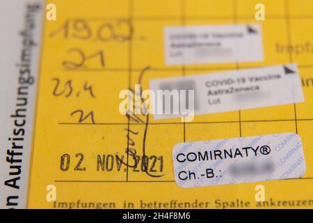 02. November 2021, Bayern, Erlangen: Der dritte Aufkleber der Impfung gegen Covid-19 steht in einem Impfbuch eines älteren Mannes nach seiner Auffrischungsimpfung in einem temporären mobilen Impfzentrum. In Bayern. Das bayerische Impfzentrum hat nach wie vor mobile Teams in Erlangen, Deutschland. Termine sind für Personen ab 12 Jahren ohne Anmeldung möglich. Impfstoffe von BioNTech/Pfizer und Johnson & Johnson werden bei allen Terminen angeboten. Foto: Daniel Karmann/dpa - ACHTUNG: Die Chargennummern des Impfstoffs sind aus rechtlichen Gründen verpixelt Stockfoto