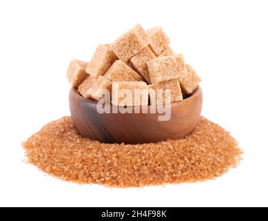 Brauner Zucker in Holzschüssel, isoliert auf weißem Hintergrund. Haufen von Rohrzuckerkristallen und Zuckerwürfeln. Stockfoto