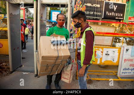 Neu Delhi, Indien-Okt 31 2021: Privates Sicherheitspersonal überprüft Einen Besucher mit einem Metalldetektor am Eingang des Lajpat nagar-Marktes. Eilen Sie voran Stockfoto