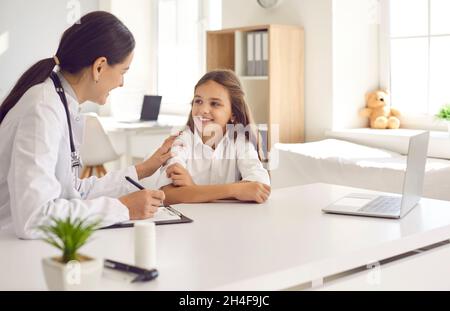 Freundliche und fürsorgliche Ärztin ermutigt kleine Mädchen vor einer ärztlichen Untersuchung. Stockfoto