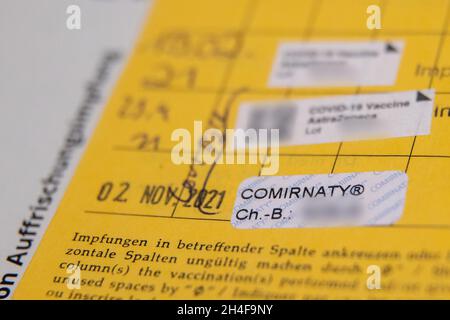 02. November 2021, Bayern, Erlangen: Der dritte Aufkleber der Impfung gegen Covid-19 steht in einem Impfbuch eines älteren Mannes nach seiner Auffrischungsimpfung in einem temporären mobilen Impfzentrum. In Bayern. Das bayerische Impfzentrum hat nach wie vor mobile Teams in Erlangen, Deutschland. Termine sind für Personen ab 12 Jahren ohne Anmeldung möglich. Impfstoffe von BioNTech/Pfizer und Johnson & Johnson werden bei allen Terminen angeboten. Foto: Daniel Karmann/dpa - ACHTUNG: Die Chargennummern des Impfstoffs sind aus rechtlichen Gründen verpixelt Stockfoto