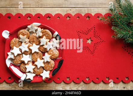 Overhead Foto bunte weihnachten flach lag mit weihnachtsplätzchen auf Teller auf roten Läufer. Stockfoto