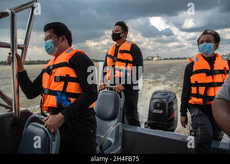 Samut Prakarn, Thailand. November 2021. Zollbeamte, die im Dienst waren, um eine Rettung des angefallenen Frachtschiffes "O.P.K 3" zu beobachten, nachdem sie vom Frachtschiff "NP Pathum Thani" getroffen wurden.zwei Frachtschiffe mit vollen Containern kollidierten mitten im Fluss vor der Provinzhalle von Samut Prakan. Eines der Frachtschiffe namens „O.P.K 3“ wurde nach dem Zusammenstößen gekentert, aber es wurden keine Besatzungsmitglieder verletzt. Kredit: SOPA Images Limited/Alamy Live Nachrichten Stockfoto