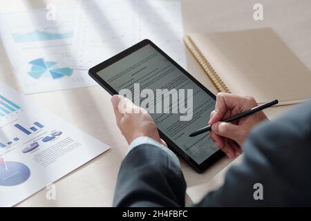 Hände von Geschäftsmann mit digitalen Stift Lesen und Signieren Dokument auf Tablet-Computer Stockfoto