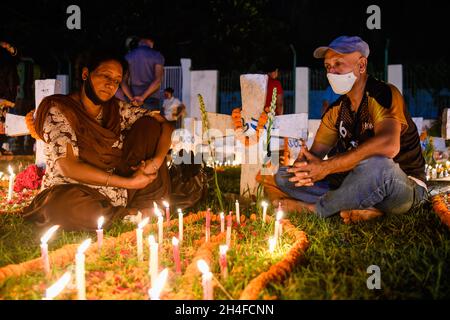 Dhaka, Bangladesch. November 2021. Christliche Anhänger sitzen am Grab eines Familienmitglieds, um den Tag der Seelen auf dem Friedhof der heiligen Rosenkranzkirche in Tejgaon in Dhaka zu feiern.der Tag der Seelen, auch bekannt als Gedenken an alle verstorbenen Heiligen, ist ein Tag des Gebets und der Erinnerung für die Gläubigen Verstorbenen, Die von Katholiken und anderen christlichen Konfessionen jährlich am 2. November beobachtet wird. Kredit: SOPA Images Limited/Alamy Live Nachrichten Stockfoto