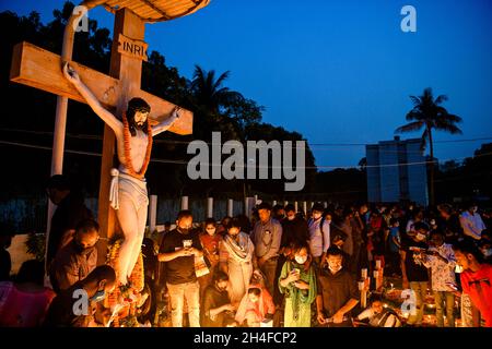 Dhaka, Bangladesch. November 2021. Christliche Gläubige respektieren und halten Kerzen an den Gräbern von Familienmitgliedern, um den Tag der Seelen auf dem Friedhof der heiligen Rosenkranzkirche in Tejgaon in Dhaka zu feiern.der Tag der Seelen, auch bekannt als Gedenken an alle verstorbenen Heiligen, ist ein Tag des Gebets und der Erinnerung für die Gläubigen Verstorbenen, Die von Katholiken und anderen christlichen Konfessionen jährlich am 2. November beobachtet wird. Kredit: SOPA Images Limited/Alamy Live Nachrichten Stockfoto