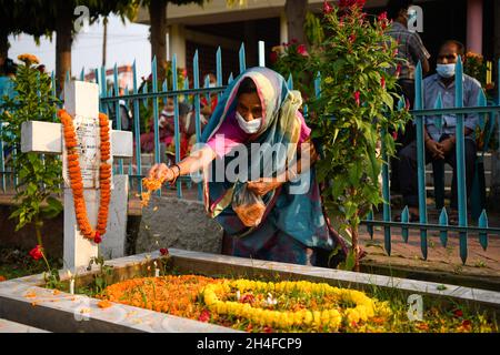 Dhaka, Bangladesch. November 2021. Ein christlicher Gläubiger besprüht Blumen am Grab eines Familienmitglieds, um den All Souls Day auf dem Friedhof der heiligen Rosenkranzkirche in Tejgaon in Dhaka zu feiern.der All Souls' Day, auch bekannt als Gedenken an alle verstorbenen Heiligen, ist ein Tag des Gebets und der Erinnerung an die Gläubigen Verstorbenen, Die von Katholiken und anderen christlichen Konfessionen jährlich am 2. November beobachtet wird. Kredit: SOPA Images Limited/Alamy Live Nachrichten Stockfoto