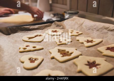 Nahaufnahme von Frauen, die zu Hause Weihnachtskekse backen. Stockfoto