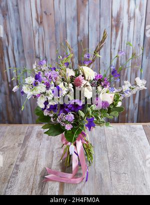 Ein Hochzeitsstrauß mit einer hölzernen Wand aus Holz. Frischer, üppiger Blumenstrauß Stockfoto