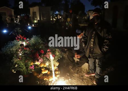 Nicht exklusiv: Blick auf ein Grab auf dem Friedhof von San Pedro Tláhuac, um die Ankunft ihrer verstorbenen Angehörigen zu erwarten, Verwandte schmücken mit Blumen, b Stockfoto