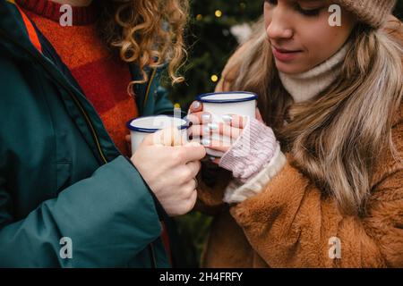 Nettes Paar mit Winter Forest Picknick trinken Tee aus Tee-Cup. Natur Picknick im Wald. Liebesgeschichte Datum am Auto.Nahaufnahme Hände Stockfoto
