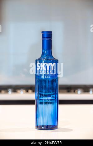 CALGARY, KANADA - 08. Oktober 2021: Eine vertikale Aufnahme eines Skyy Vodka-Getränks in einer blau-transparenten Glasflasche auf einem weißen Küchentisch Stockfoto