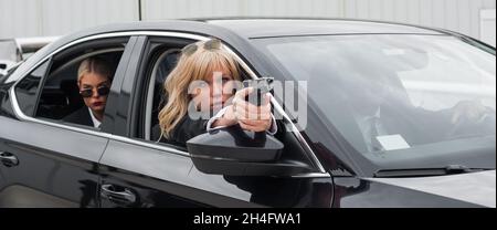 Professionelle bewaffnete Team von weiblichen und männlichen Bodyguards schießen und schützen eine VIP-Prominenten Person in der Auto-Limousine. Bodyguard und VIP Person Security Pro Stockfoto