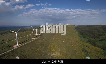 Drohnenansicht eines Windparks auf einem Berg mit Gras und einem Himmel mit Wolken Stockfoto