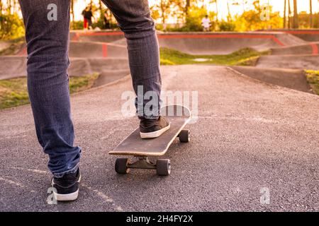 Skateboarder üben an einem sonnigen Tag auf einem Pump Track Park. Stockfoto