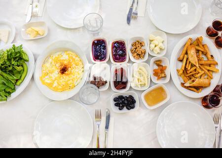 Klassisches türkisches Frühstück - Omelette, Quark, Marmelade, Honig, Nüsse, Gebratene Kartoffeln, Kräuter, Tee. Stockfoto