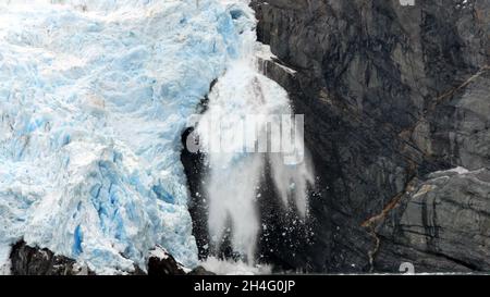 Vorderansicht eines Gletschereisbrockens, das aufgrund der Auswirkungen des Klimawandels abbricht und ins Meer fällt. Stockfoto