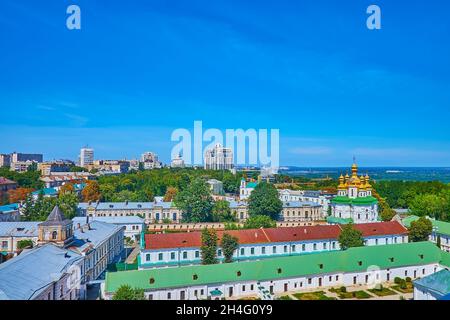 Historisches Stadtbild mit grünen Dächern der Kiewer Pechersk Lavra-Gebäude und den goldenen Kuppeln der Allerheiligen Kirche des Lavra-Höhlenklosters im Hintergrund Stockfoto