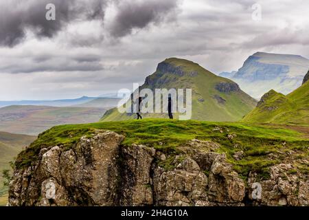 ISLE OF SKYE, SCHOTTLAND - 04 2021. SEPTEMBER: Wanderer mit dramatischer Bergkulisse und launischem Himmel am Quiraing-Bergschlupf auf der Isle Stockfoto