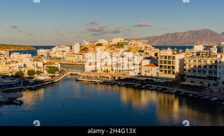 AGIOS NIKOLAOS, GRIECHENLAND - 24 2021. SEPTEMBER: Panoramablick auf den Sonnenuntergang über dem See in der Stadt Agios Nikolaos in der Lasithi-Region des Griechen i. Stockfoto