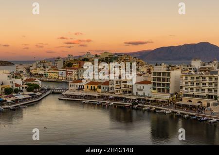 AGIOS NIKOLAOS, GRIECHENLAND - 24 2021. SEPTEMBER: Panoramablick auf den Sonnenuntergang über dem See in der Stadt Agios Nikolaos in der Lasithi-Region des Griechen i. Stockfoto