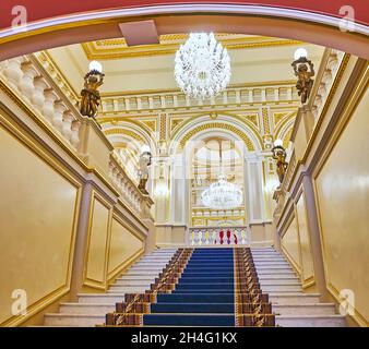 KIEW, UKRAINE - 25. JUNI 2021: Die Haupttreppe des Mariinskyi-Palastes mit Blick auf die Bronzeskulpturen, Lampen und die schönen Glasleuchter Stockfoto