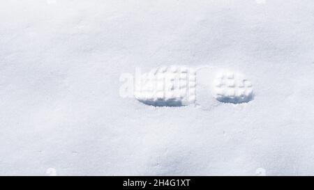 Ein Schritt, menschliche Fußabdrücke im frischen weißen Schnee. Konzept Stockfoto
