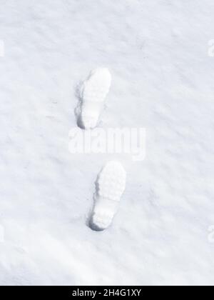 Schritt für Schritt (menschliche Fußabdrücke) im frischen weißen Schnee. Konzept Stockfoto