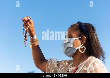 Salvador, Bahia, Brasilien - 01. Januar 2021: Frau mit Gesichtsmaske und Gebet in der Senhor do Bonfim Kirche in Salvador, Bahia, Brasilien. Stockfoto